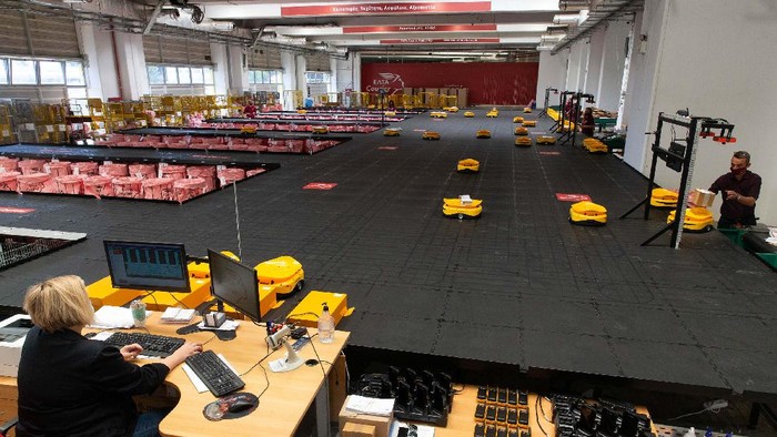Robot Mungil Ini 'Dipekerjakan' Perusahaan Pos Yunani (210921) -- ATHENA, 21 September, 2021 (Xinhua) -- Para karyawan perusahaan penyedia layanan pos nasional Yunani, Hellenic Post (ELTA), bekerja dengan sistem robotik buatan China untuk menyortir barang kiriman di fasilitas milik ELTA di Kryoneri, wilayah pinggiran di sebelah utara Athena, Yunani, pada 14 September 2021. ELTA sudah mulai menggunakan sistem robotik buatan China untuk menyortir barang kiriman, menargetkan untuk mempercepat proses dan meningkatkan kualitas layanan bagi pelanggan. Sistem otomatis yang sepenuhnya terdigitalisasi itu dikembangkan oleh perusahaan China Zhejiang LiBiao Robot Co., Ltd. Sejak pertengahan Agustus, armada yang terdiri dari 55 robot mungil berwarna kuning ini telah bergabung dengan para karyawan di sejumlah fasilitas milik perusahaan layanan pos itu di Kryoneri. (Xinhua/Marios Lolos)
