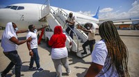 Polisi dan sejumlah petugas bandara pun bertindak untuk menghalangi para warga Haiti untuk kembali masuk ke pesawat.