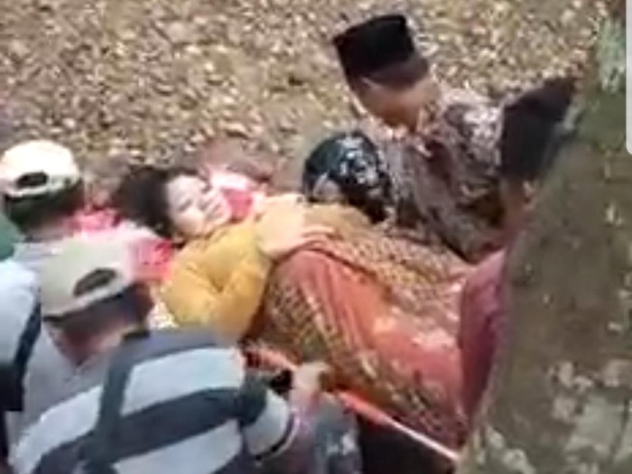 Seorang perempuan yang hendak melahirkan di Jember ditandu menyeberangi sungai. Sebab, jembatan di daerah tersebut rusak dan dalam proses perbaikan.
