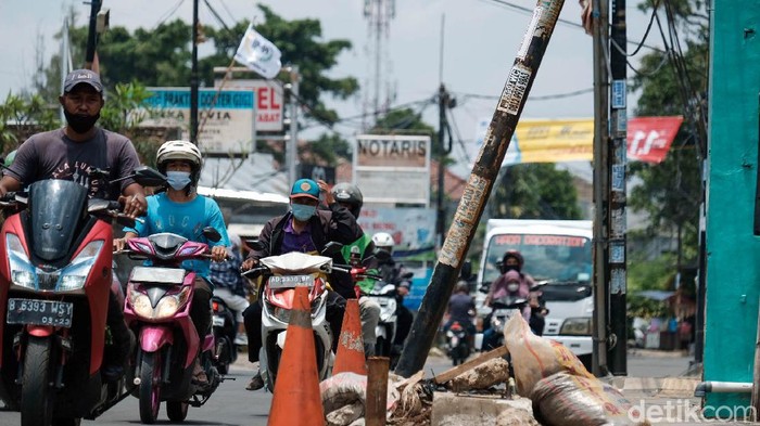 Tiang makan jalan di Jl WR Supratman, Ciputat Timur, Tangsel, tak kunjung dipindahkan. Malahan ada satu tiang yang terpantau makin membahayakan pengguna jalan.