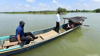 Jokowi menyeberangi sungai untuk menyapa warga secara langsung. Jokowi naik perahu bersama tiga nelayan dan hanya didampingi oleh Komandan Grup A Paspampres Anan Nurakhman. (Foto: Agus Suparto)