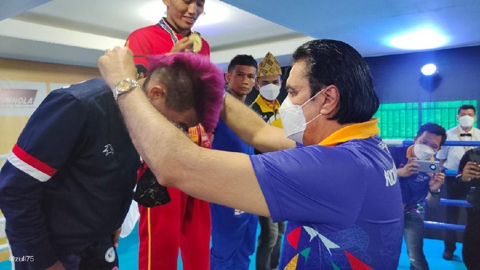 Bendahara Umum PP KBI, Karan Sukarno Walia, sedang mengalungkan medali kepada juara eksebisi Kickboxing PON XX Papua.