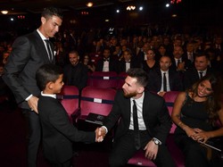 Di luar lapangan, Ronaldo dan Messi tak bisa dibilang dekat. Tapi mereka juga tidak bermusuhan. Ini salah satu momen hangat Ronaldo memperkenalkan putranya ke Messi. Foto: AFP/BEN STANSALL