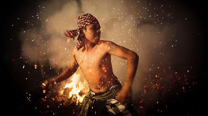 Mengusir Petaka Lewat Tradisi Perang Api di Gianyar Bali GIANYAR, BALI, INDONESIA - MARCH 30: A Balinese man hits another with a burned coconut husk during the