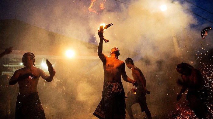 GIANYAR, BALI, INDONESIA - MARCH 30:  A Balinese man hits another with a burned coconut husk during the 