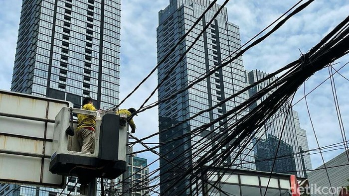 Petugas melakukan penataan jaringan utilitas di Jalan Wolter Monginsidi, Jakarta Selatan, Kamis (23/09/2021).