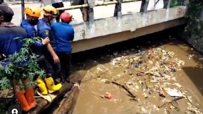 Petugas PUPR Depok membersihkan sampah yang menyumbat Kali Mampang hingga menimbulkan banjir di Sawangan