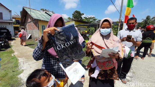 Presiden Joko Widodo bagi-bagi kaus dan masker ke warga Cilacap, Kamis (23/9/2021).