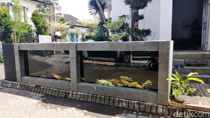 Rumah warga di Perum Tirtasari, Kecamatan Wagir, Kabupaten Malang, sungguh unik. Pagar rumahnya dibuat dari kolam koi.