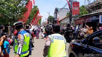 Petugas kewalahan menghadang warga yang berhamburan mendekati mobil Jokowi itu. Imbauan petugas untuk menjaga jarak pun tak diindahkan.