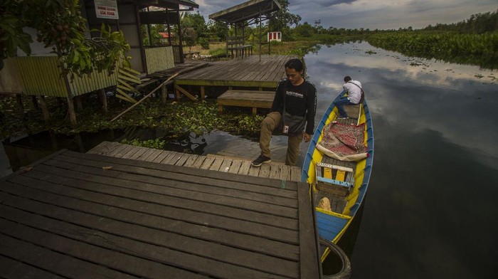 WISATA RELIGI DENGAN MENYUSUR SUNGAI DI KALSEL Peziarah berjalan di kawasan wisata religi makam Syekh Muhammad Ilyas (Datu Muning) di Desa Sungai Rutas, Kabupaten Tapin, Kalimantan Selatan, Kamis (23/9/2021). Kabupaten Tapin terkenal mempunyai obyek wisata religi yang menarik dikunjungi salah satunya makam Datu Muning dan untuk menuju ke makam tersebut pengunjung diajak menyusuri sungai Rutas menggunakan kelotok (perahu bermesin). ANTARA FOTO/Bayu Pratama S/foc.