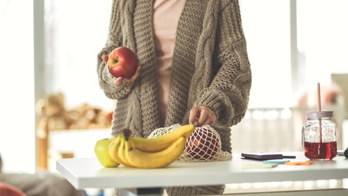 Ilustrasi wanita makan buah apel dan pisang