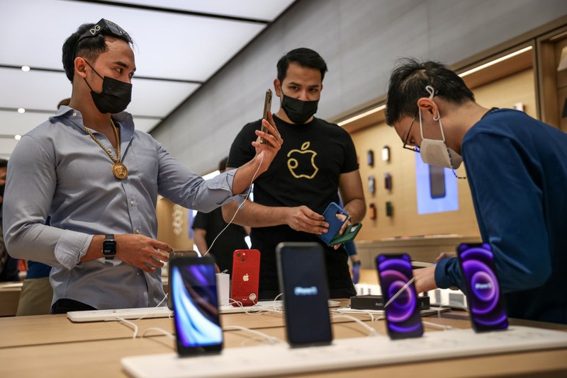 SINGAPORE, SINGAPORE - SEPTEMBER 24: People try out newly released products at the Apple Store in Orchard Road on September 24, 2021 in Singapore. Apple announced September 14 the release of four variants of its latest iPhone 13, alongside other upgrades to its product lineup. (Photo by Feline Lim/Getty Images)