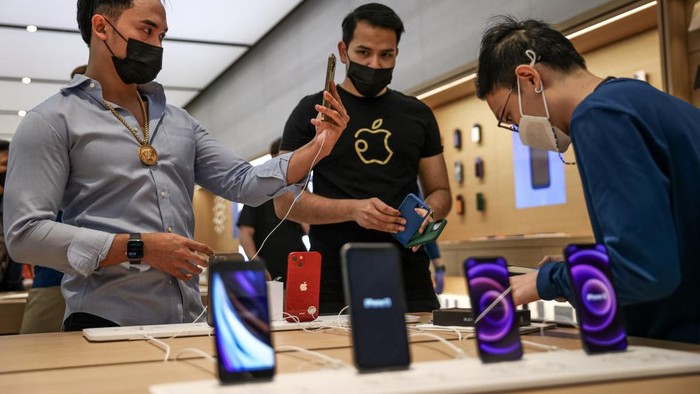 SINGAPORE, SINGAPORE - SEPTEMBER 24: People try out newly released products at the Apple Store in Orchard Road on September 24, 2021 in Singapore. Apple announced September 14 the release of four variants of its latest iPhone 13, alongside other upgrades to its product lineup. (Photo by Feline Lim/Getty Images)
