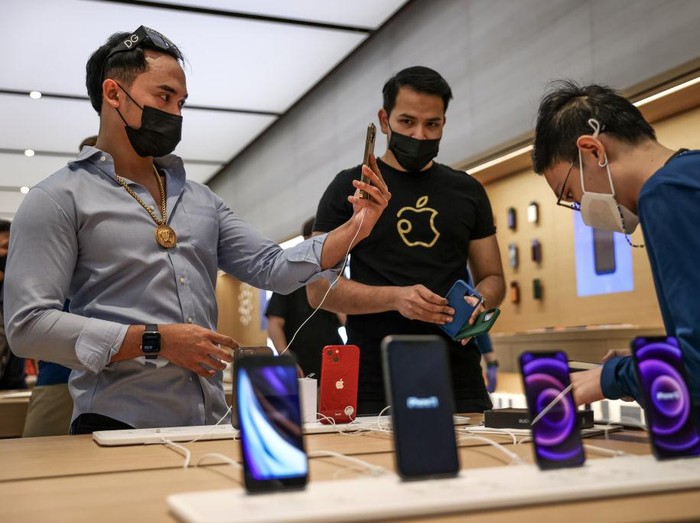 SINGAPORE, SINGAPORE - SEPTEMBER 24: People try out newly released products at the Apple Store in Orchard Road on September 24, 2021 in Singapore. Apple announced September 14 the release of four variants of its latest iPhone 13, alongside other upgrades to its product lineup. (Photo by Feline Lim/Getty Images)