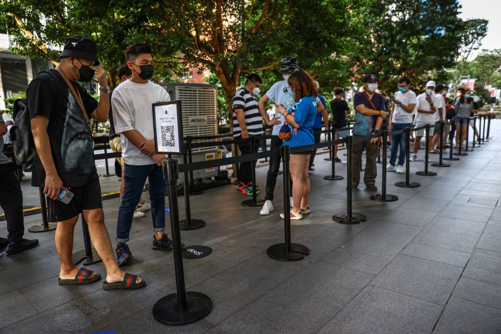 People wait in line to purchase newly released products at the Apple Store in Orchard Road on September 24, 2021 in Singapore. Apple announced September 14 the release of four variants of its latest iPhone 13, alongside other upgrades to its product lineup. (Photo by Feline Lim/Getty Images)