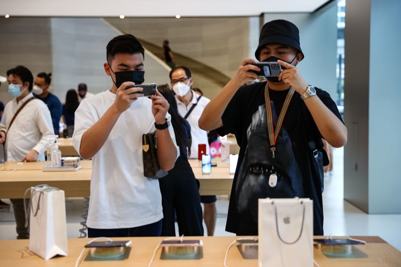 People wait in line to purchase newly released products at the Apple Store in Orchard Road on September 24, 2021 in Singapore. Apple announced September 14 the release of four variants of its latest iPhone 13, alongside other upgrades to its product lineup. (Photo by Feline Lim/Getty Images)