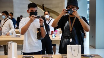 Haikal Putra (kanan) dan Wayne Chang (kiri) mencoba produk yang baru dirilis di Apple Store di Orchard Road Foto: Feline Lim/Getty Images