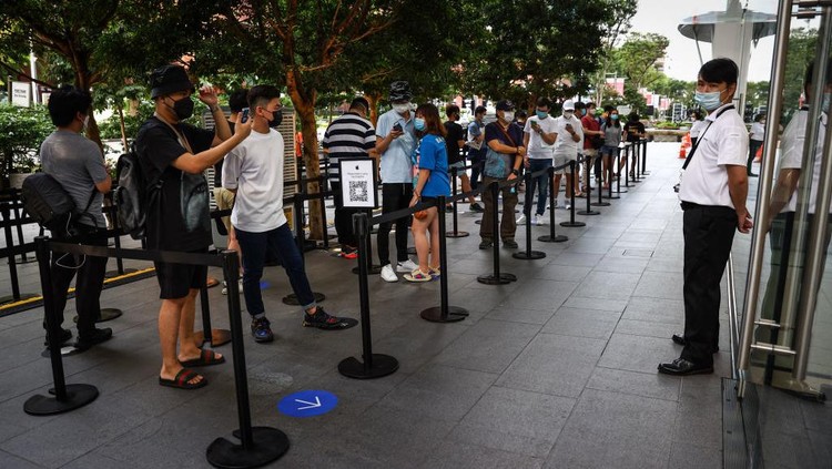 Penjualan iPhone 13 di Singapura People wait in line to purchase newly released products at the Apple Store in Orchard Road on September 24, 2021 in Singapore. Apple announced September 14 the release of four variants of its latest iPhone 13, alongside other upgrades to its product lineup. (Photo by Feline Lim/Getty Images)