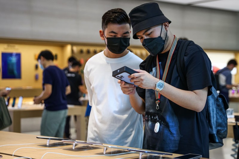 People wait in line to purchase newly released products at the Apple Store in Orchard Road on September 24, 2021 in Singapore. Apple announced September 14 the release of four variants of its latest iPhone 13, alongside other upgrades to its product lineup. (Photo by Feline Lim/Getty Images)