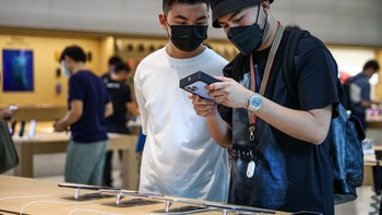 Haikal Putra (kanan) dan Wayne Chang (kiri) membeli iPhone 13 Pro Max. Foto: Feline Lim/Getty Images