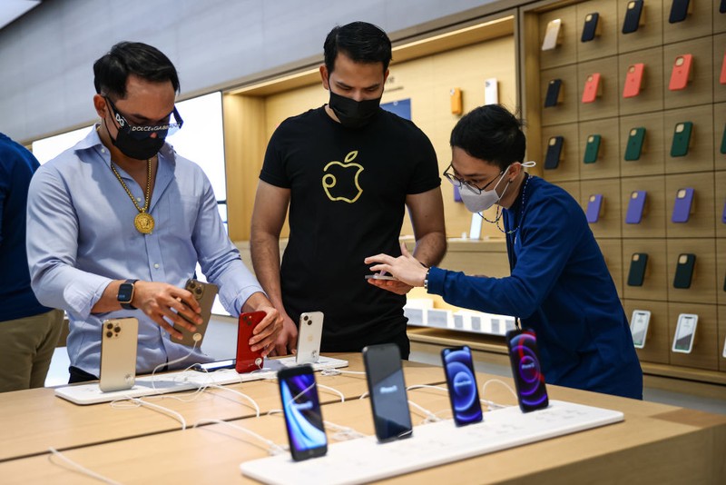 People wait in line to purchase newly released products at the Apple Store in Orchard Road on September 24, 2021 in Singapore. Apple announced September 14 the release of four variants of its latest iPhone 13, alongside other upgrades to its product lineup. (Photo by Feline Lim/Getty Images)