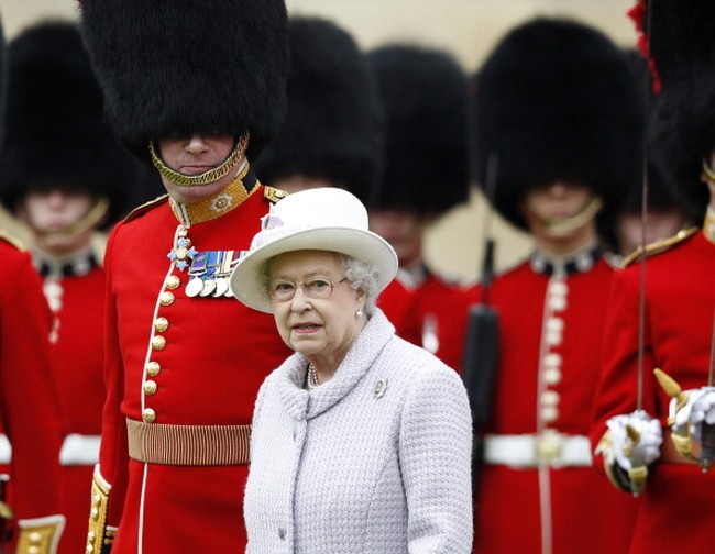 Topi bulu tinggi yang dipakai penjaga istana Inggris jadi salah satu ikon unik negara Ratu Elizabeth II itu. Tapi, tahukah kamu awal mula topi bulu tinggi itu?