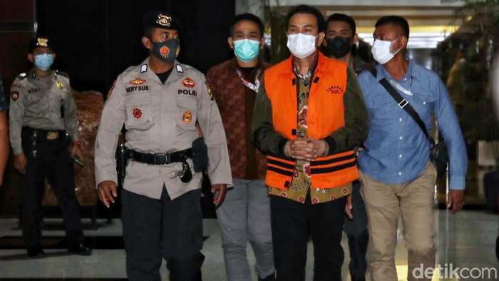 Wakil Ketua DPR Fraksi Golkar Azis Syamsuddin mengenakan baju tahanan berjalan menuju mobil tahana  di Gedung KPK,Kuningan,  Jakarta Selatan, Sabtu dinihari (25/9). Azis resmi ditahan KPK sebagai tersangka terkait kasus dugaan pengurusan Dana Alokasi Khusus (DAK) Kabupaten Lampung Tengah tahun 2017.