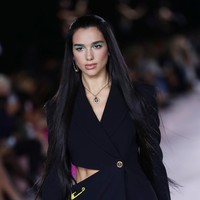 Di catwalk, Dua Lipa menebar pesonanya dalam balutan blazer dengan detail cut-out nan seksi di bagian pinggang dan rok pensil senada. Tak ketinggalan safety pins khas Versace turut menghiasi busana tersebut. (Foto: Getty Images/Vittorio Zunino Celotto)