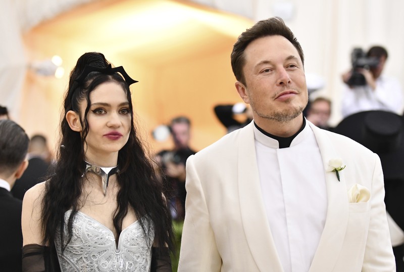 FILE - Grimes, left, and Elon Musk attend The Metropolitan Museum of Art's Costume Institute benefit gala in New York on May 7, 2018. The Tesla and SpaceX founder tells the New York Post that he and the Canadian singer are “semi-separated.” But he says they remain on good terms, she still lives at his house in California and they continue to raise their 1-year-old son together. (Photo by Charles Sykes/Invision/AP, File)
