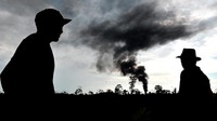 Warga melihat kepulan asap yang keluar dari sumur minyak ilegal yang terbakar di Bungku, Bajubang, Batanghari, Jambi, Minggu (26/9/2021).