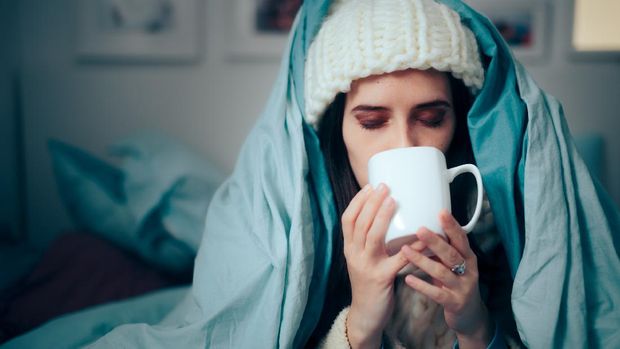 Sick person with flu symptoms using natural medicine treatment infusion tea
