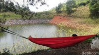 Tampak pengunjung sedang bersantai di atas hammock sambil menikmati keindahan permukaan air Cekdam Cimarias.