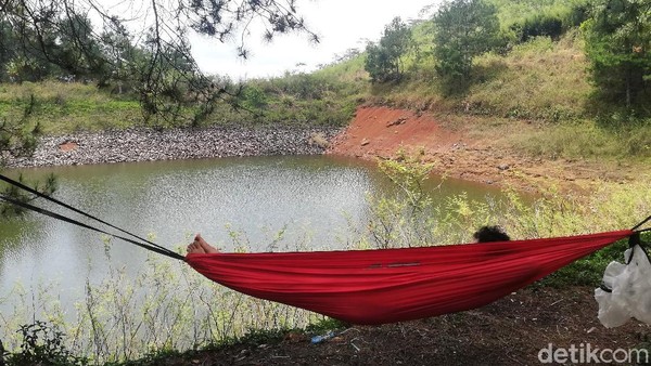 Tampak pengunjung sedang bersantai di atas hammock sambil menikmati keindahan permukaan air Cekdam Cimarias. Tampak pengunjung sedang bersantai di atas hammock sambil menikmati keindahan permukaan air Cekdam Cimarias.
