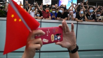 Kerumunan di belakang bersorak seiring kedatangan bos Huawei. Sebagian menyanyikan lagu-lagu bernada patriotisme. Foto: AP