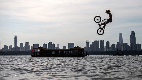 Seorang pesepeda melompati danau saat ambil bagian dalam festival lompat air yang digelar di Wuhan, Provinsi Hubei, China, Sabtu (25/9/2021). Seorang pesepeda melompati danau saat ambil bagian dalam festival lompat air yang digelar di Wuhan, Provinsi Hubei, China, Sabtu (25/9/2021).
