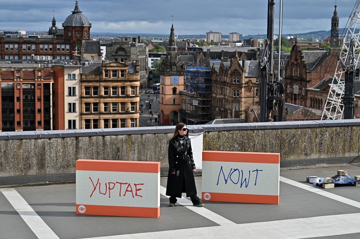 Ada-ada Saja! Seniman Glasgow Mejeng Karya di Tempat Parkir GLASGOW, SCOTLAND - SEPTEMBER 24: Artist Council Baby stands beside her work during the unveiling of an exhibition on top of multi-story carpark on September 24, 2021 in Glasgow, Scotland. The exhibition is called Graduate Drive Thru and features work by 24 artists and designers who graduated from The Glasgow School of Art in 2020. (Photo by Jeff J Mitchell/Getty Images)