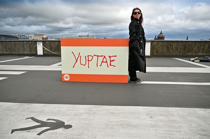 GLASGOW, SCOTLAND - SEPTEMBER 24: Artist Council Baby stands beside her work during the unveiling of an exhibition on top of multi-story carpark on September 24, 2021 in Glasgow, Scotland. The exhibition is called Graduate Drive Thru and features work by 24 artists and designers who graduated from The Glasgow School of Art in 2020. (Photo by Jeff J Mitchell/Getty Images)