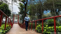 Seorang warga melintas di jembatan gantung di Taman Sumenep, Jakarta Pusat, Senin (27/9/2021).