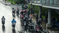 Sejumlah pemotor berteduh di bawah JPO Patra Kuningan, Jl HR Rasuna Said, Jakarta.