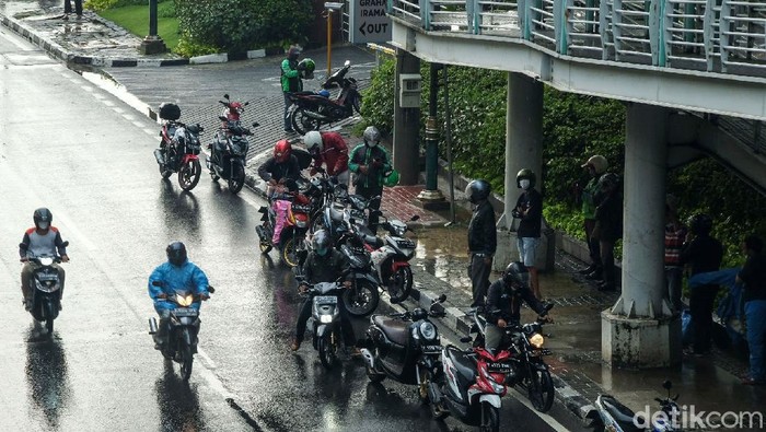 Sejumlah titik di DKI Jakarta terpantau hujan siang ini. Beberapa pemotor ada yang berteduh sampai memakan jalan.