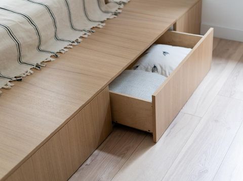 Bedroom interior, wooden bed at modern room. Furniture design with open wood drawer, white pillow decoration object in box. Brown comfortable storage for bedding cushion.