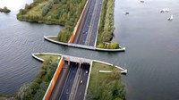 Jembatan unik yang berada di kawasan Harderwijk, Belanda ini bernama Veluwemeer Aqueduct. Dikutip dari Interesting Engineering, Veluwemeer Aqueduct sejatinya adalah sebuah jembatan air, yang dibuka pada tahun 2002 dan terletak di antara danau Veluwemeer dan jalan raya N302. Jembatan air ini dibangun sebagai solusi untuk lalu lintas kendaraan di darat dan air. Foto: Youtube/The Structures Guy.