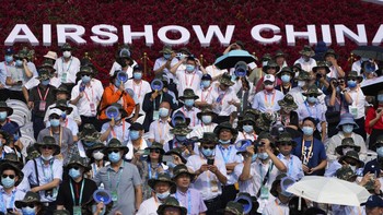 Para pengunjung menyaksikan atraksi yang ditampilkan beragam pesawat China di udara saat gelaran Airshow China 2021 berlangsung.