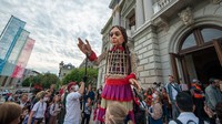 Boneka setinggi 3,5 meter berjalan dengan bantuan para senimn menuju Grand Theatre de Geneva pada 28 September 2021 di Jenewa, Swiss.  Foto: Getty Images/Robert Hradil