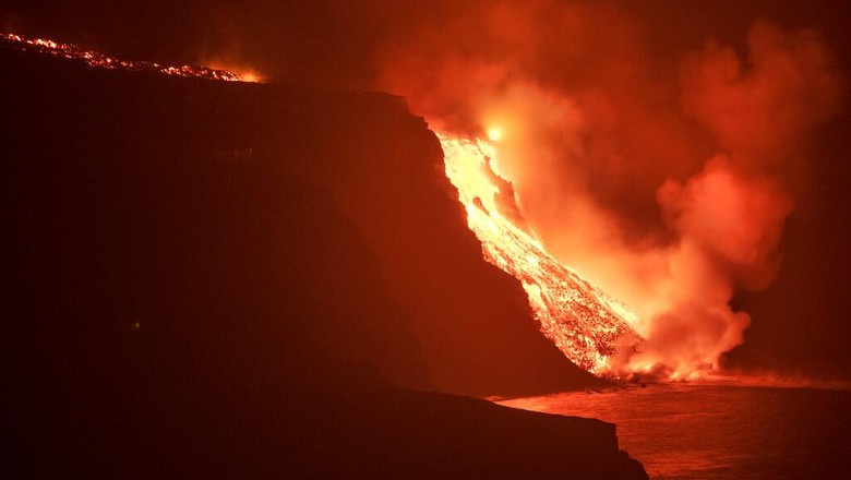 Gas Beracun Ancam Spanyol Gegara Lava Berapi Capai Lautan In this photo made available by Ume (Unidad Militar de Emergencias), Military Emergency Unit personal take gas reading measurements near a volcano on the Canary island of La Palma, Spain, in the early hours of Tuesday Sept. 28, 2021. Lava flowing from an erupting volcano on the Spanish island of La Palma has picked up pace on its way to the sea. Officials say it is now within about 800 meters (875 yards) of the shoreline. When the molten rock eventually meets the sea water it could trigger explosions and toxic gas. (Luismi Ortiz/UME via AP)