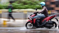 Beberapa pemotor sampai mengangkat kakinya saat menerjang genangan.