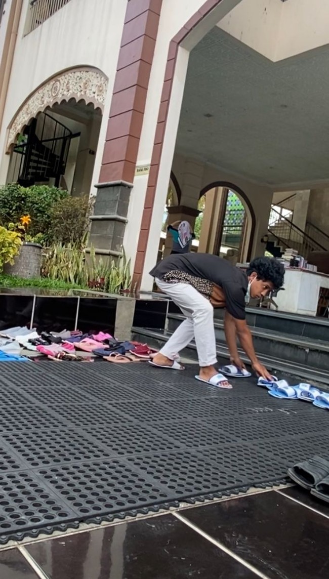 Mat Peci pun awalnya merekam diam-diam, seolah tidak memvideokan aksi remaja tersebut. Dia merekam momen remaja itu sedang sibuk merapikan sandal. Kemudian ia iseng mengunggah video remaja tersebut dan penontonnya banyak. Saat itu yang nonton sudh 6 juta Views, aku kaget. Udah gitu ada yang komen kalau remaja itu adalah pemilik masjid tersebut. Aku kaget banget, besoknya kepengen ke sana lagi dan aku mau bertanya langsung. Karena aku dapat info dari netizen. Dia yang punya resort gede banget 30 vila itu kan? takjub Mat Peci. Foto: Dok. pribadi Mat Peci.