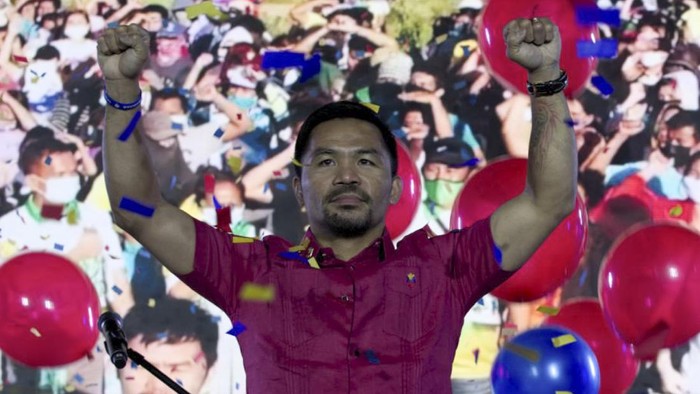 In this photo provided by the Manny Pacquiao MediaComms, Senator Manny Pacquiao raises his hands during a national convention of his PDP-Laban party in Quezon city, Philippines on Sunday Sept. 19, 2021. Philippine boxing icon and senator Manny Pacquiao says he will run for president in the 2022 elections. (Manny Pacquiao MediaComms via AP)