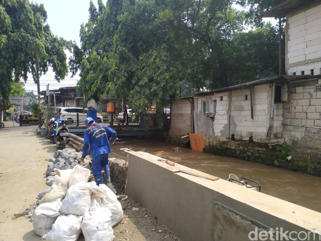 Pasukan biru membenahi tanggul Kali Baru di dekat kawasan Hek, Jl Raya Bogor, Kramat Jati, Jakarta Timur, 29 September 2021. (Athika Rahma/detikcom)